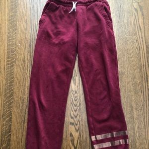 These are red sweatpants with two gold stripes.